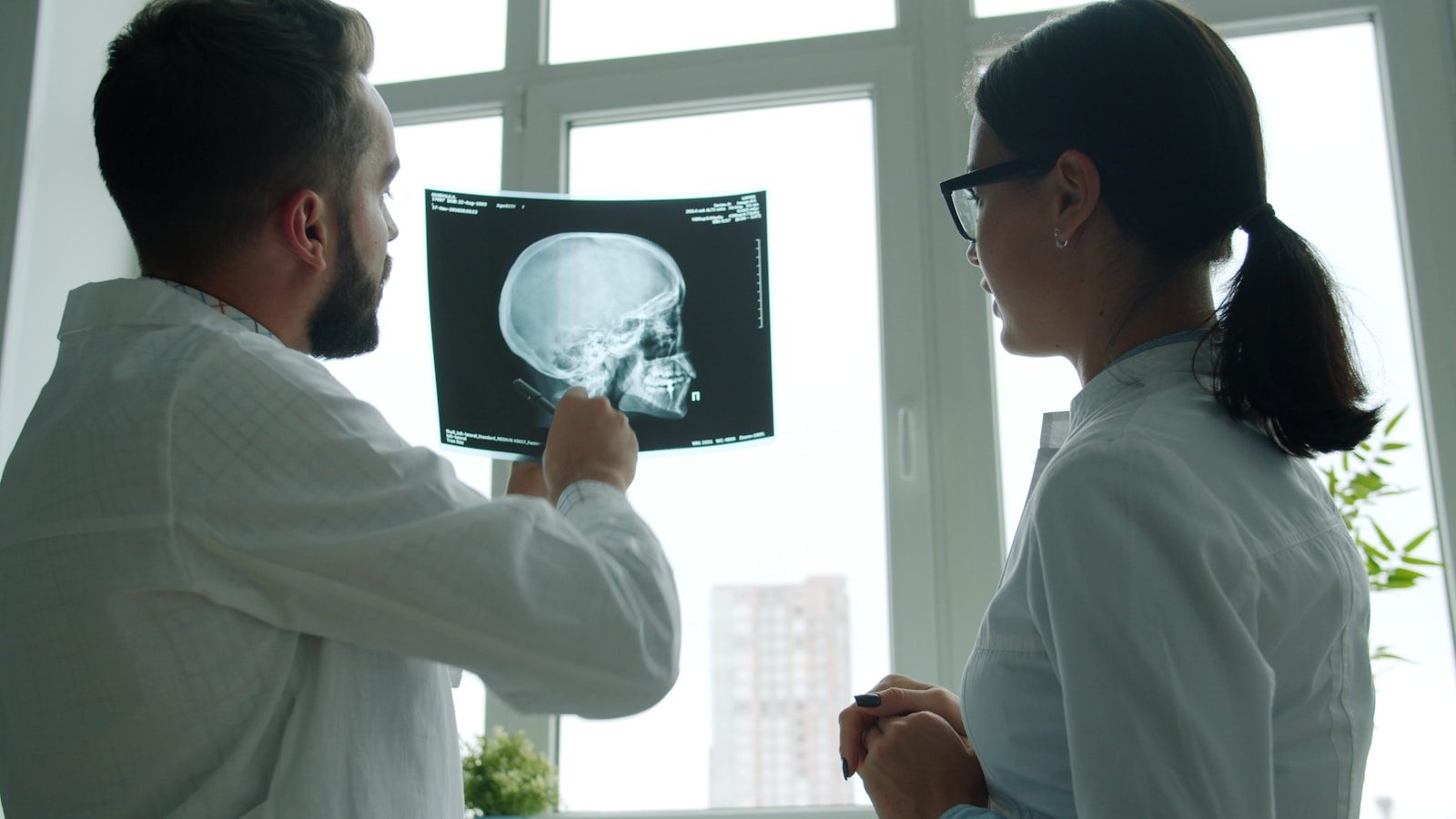 Two doctors examine a skull x-ray together