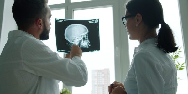 Two doctors examine a skull x-ray together